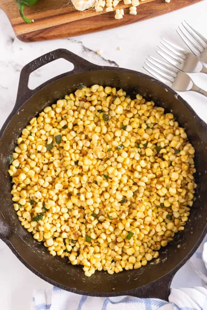 A cast iron skillet filled with corn.