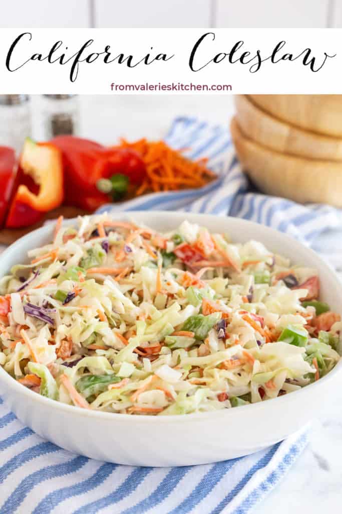 Coleslaw with shredded carrot and red and green bell pepper in a white bowl on a blue and white kitchen cloth with text overlay.