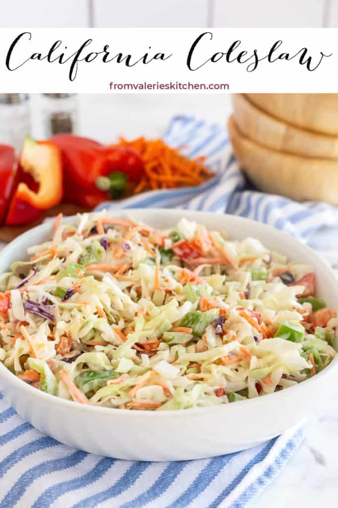 Coleslaw with shredded carrot and red and green bell pepper in a white bowl on a blue and white kitchen cloth with text overlay.