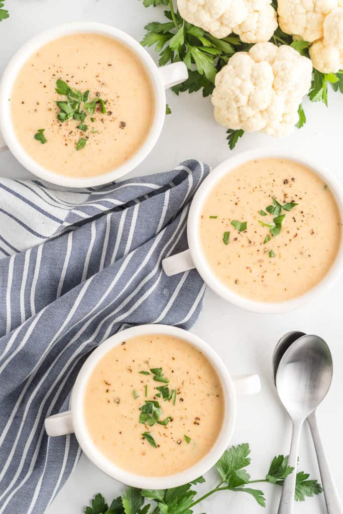Three bowls filled with Cauliflower Soup.