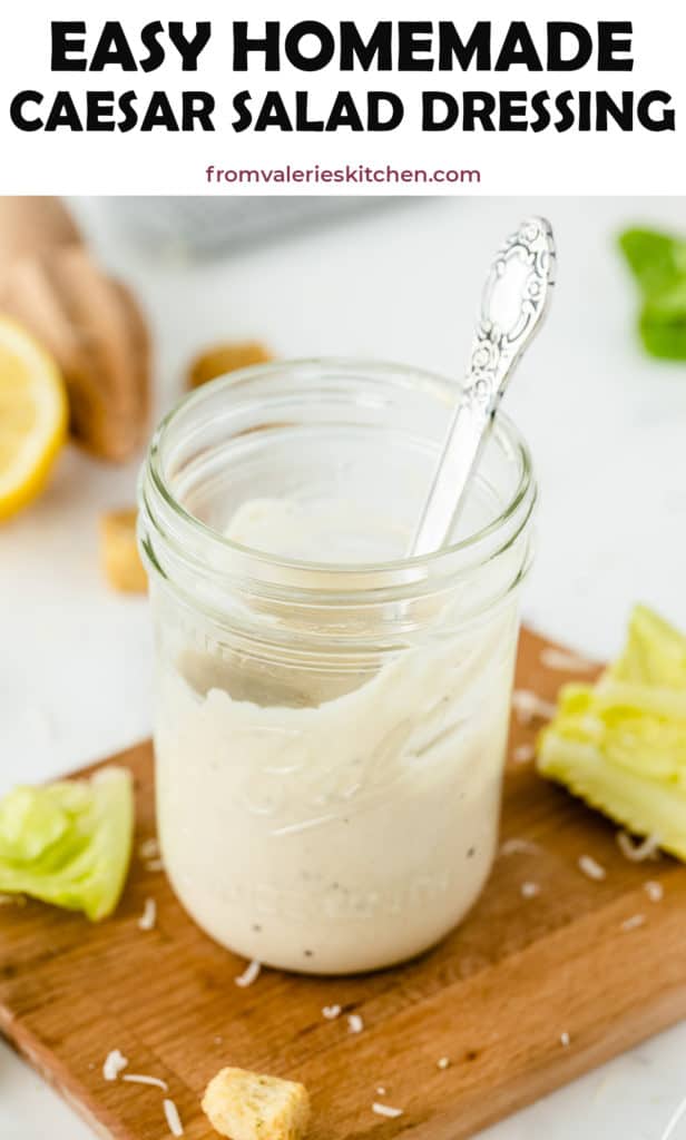 Caesar Salad Dressing in a mason jar on a cutting board with text overlay.