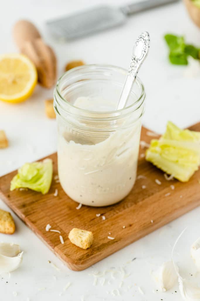 Salad dressing in a mason jar with a spoon.