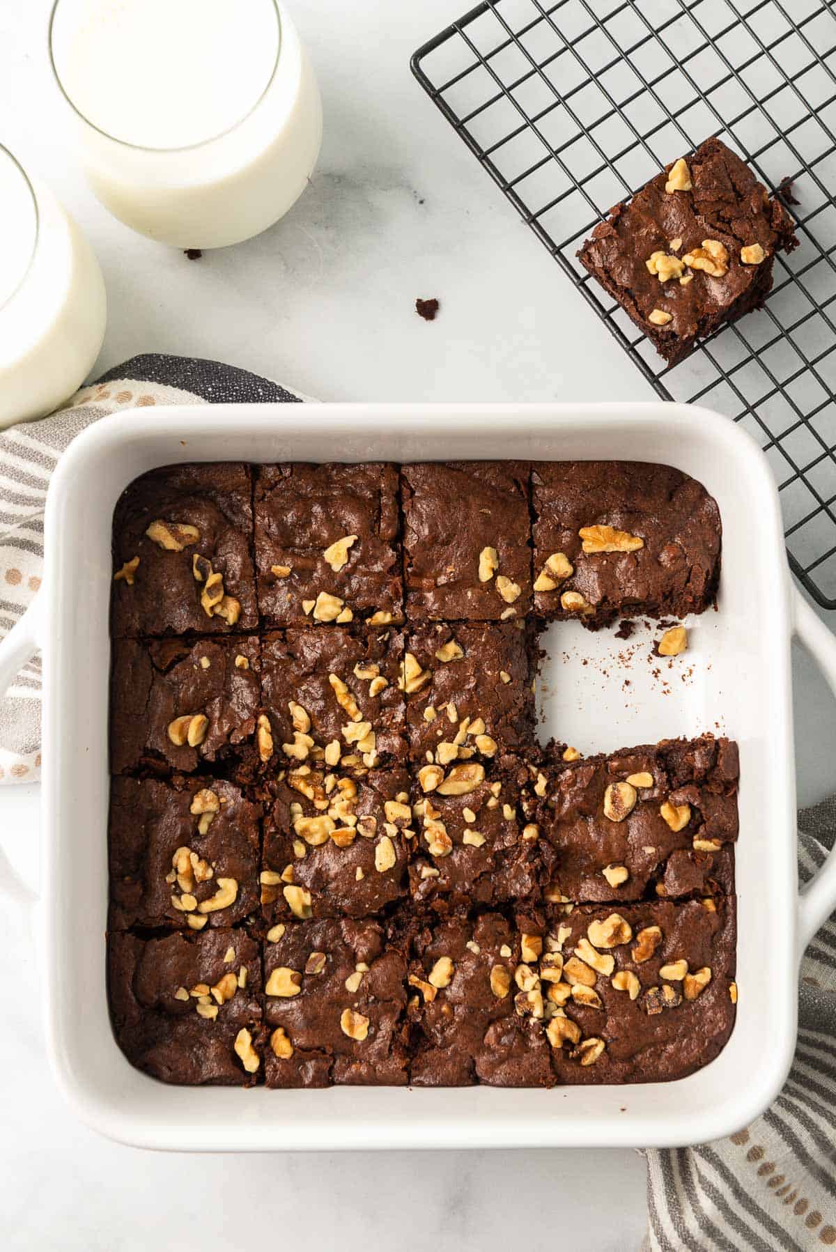 A pan of fudge walnut brownies with one missing.