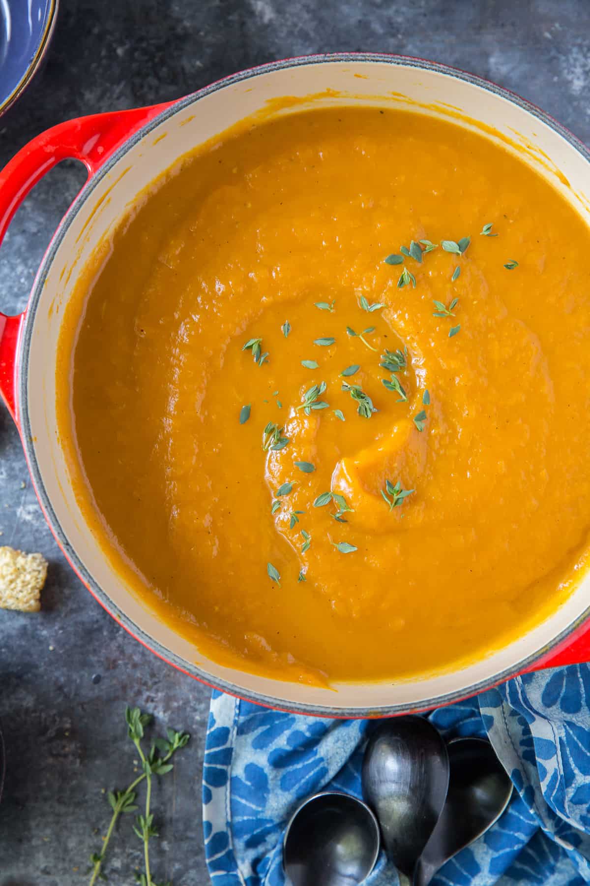 A red pot filled with Butternut Squash Soup.