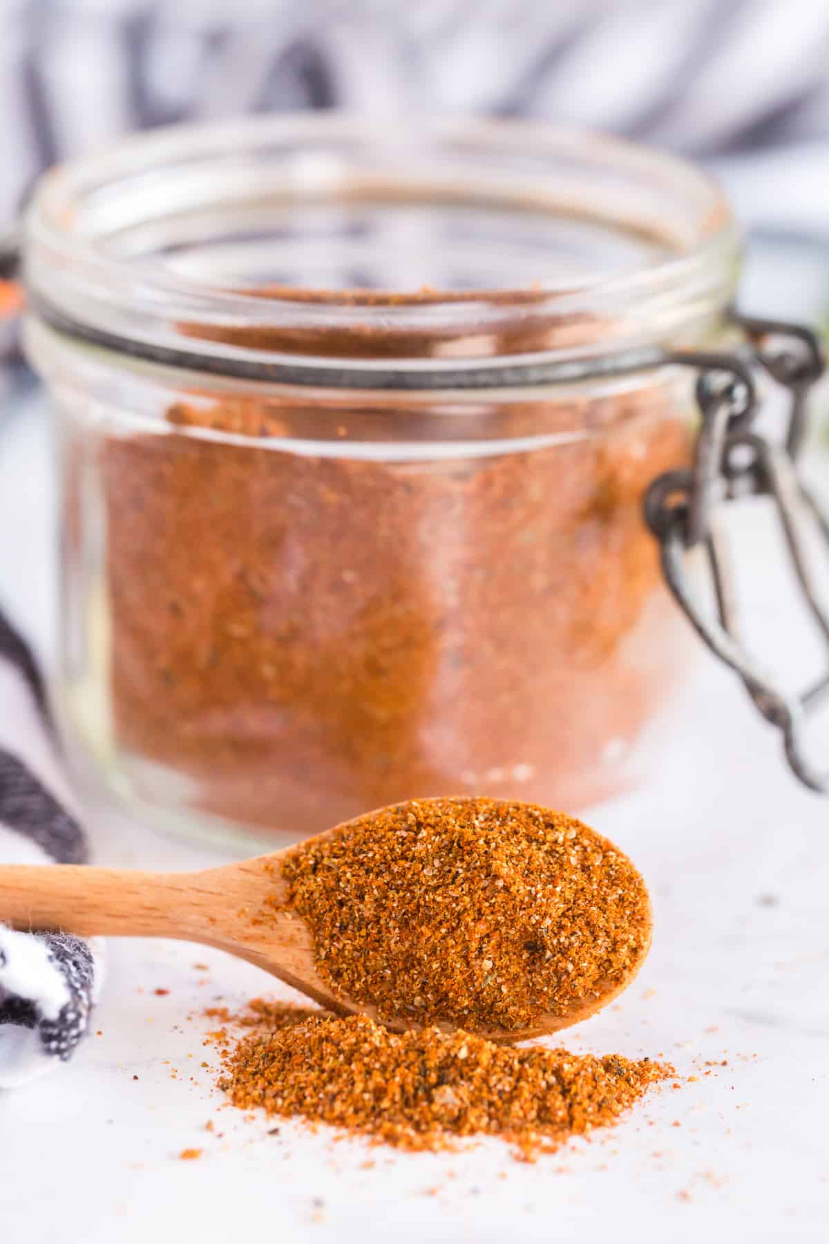 A spoon spills taco seasoning on to a counter.