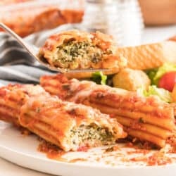 A fork lifts a bite of manicotti.