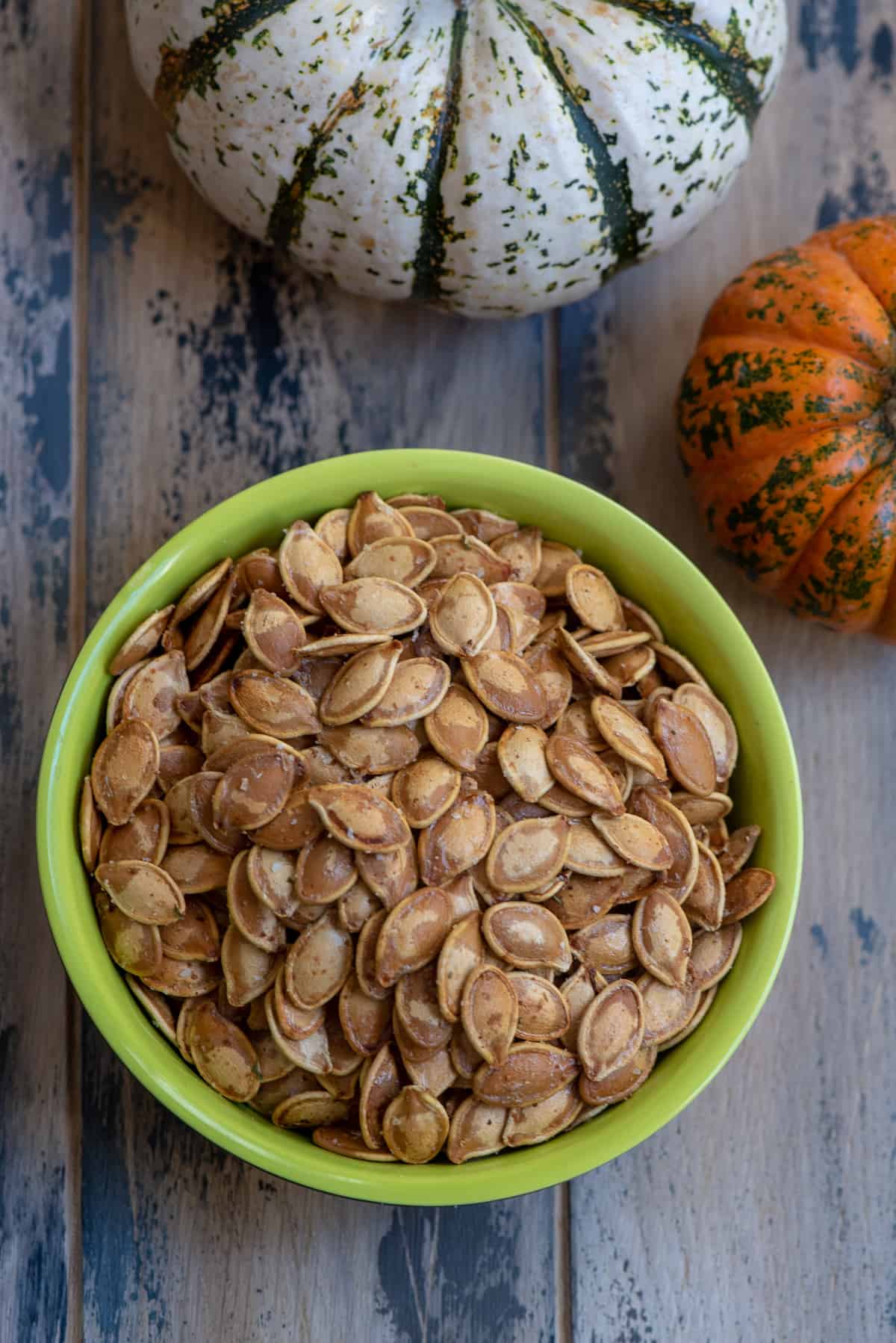 Roasted Pumpkin Seeds in a green bowl shot from the top.