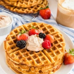 A stack of waffles topped with Maple Honey Cinnamon Butter and berries.