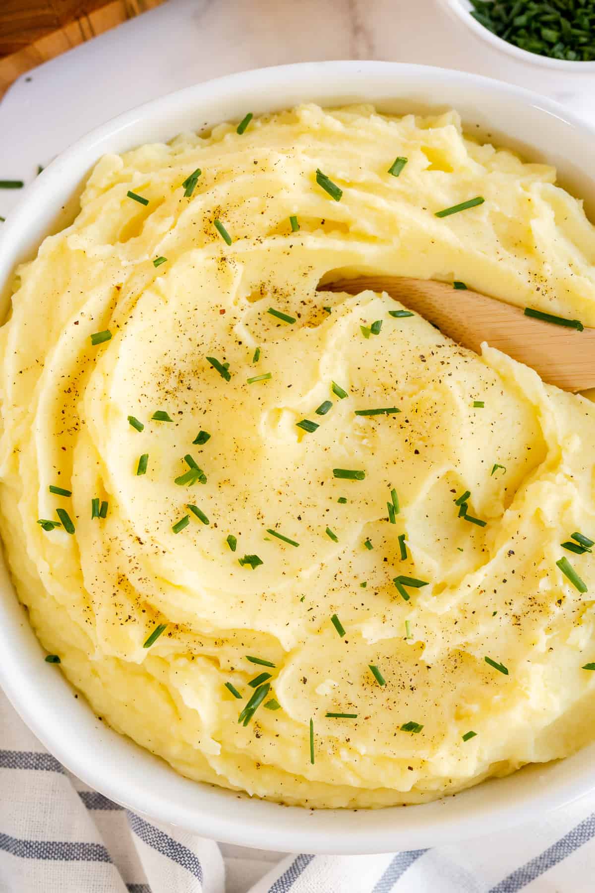Mashed Potatoes in a serving dish topped with fresh chives