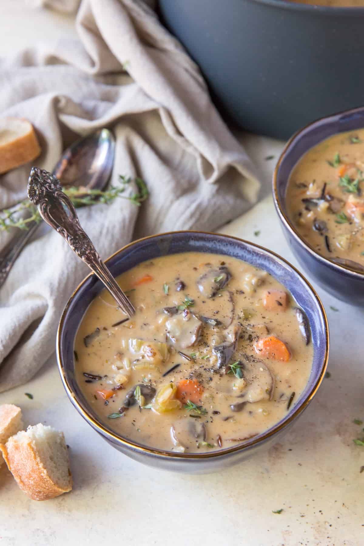 A bowl of soup in front of a big pot.