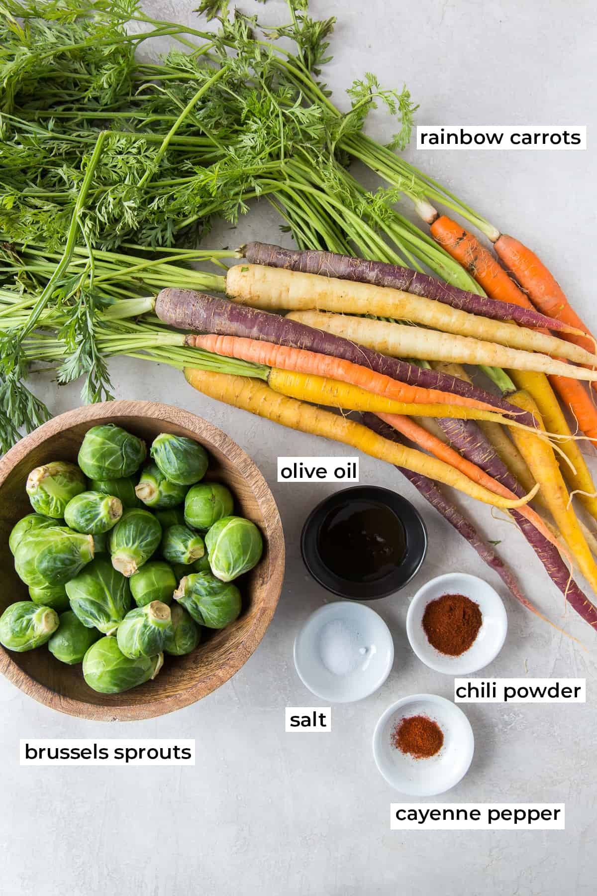 The ingredients for Honey Roasted Carrots and Brussels Sprouts with text overlay.