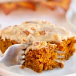 A fork breaks into a slice of pumpkin gingerbread on a plate.