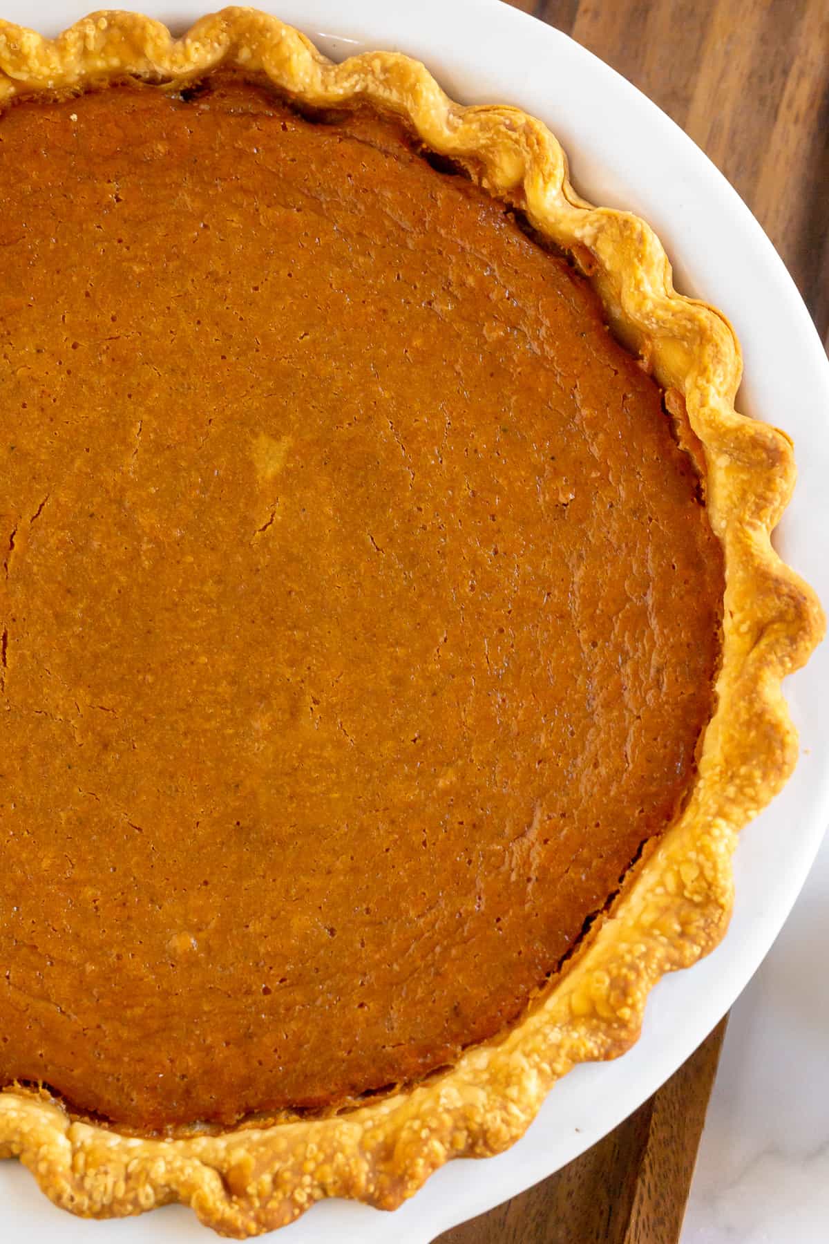 A close up of a sweet potato pie in a pie dish.