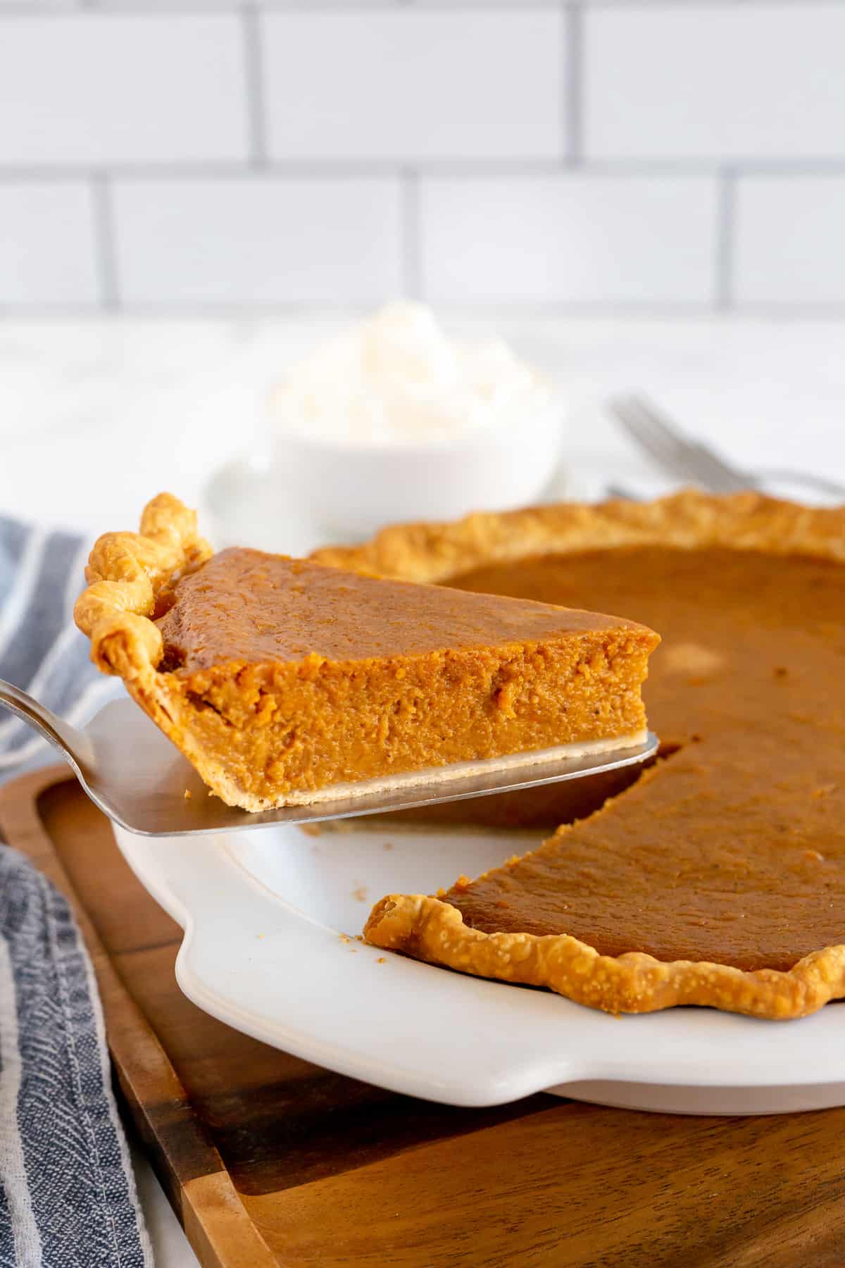 A spatula lifts a slice of pie from a pie dish.