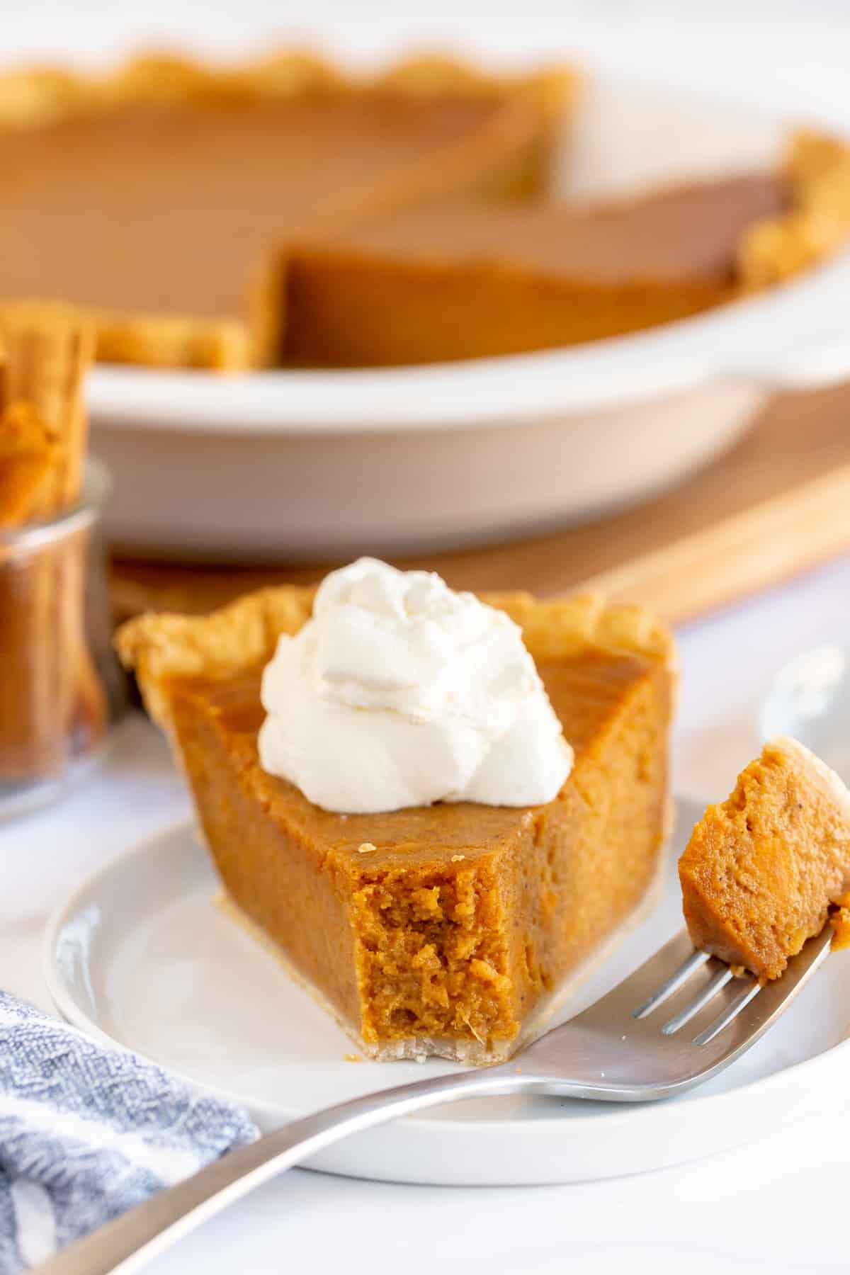 A slice of sweet potato pie on a plate with a fork.