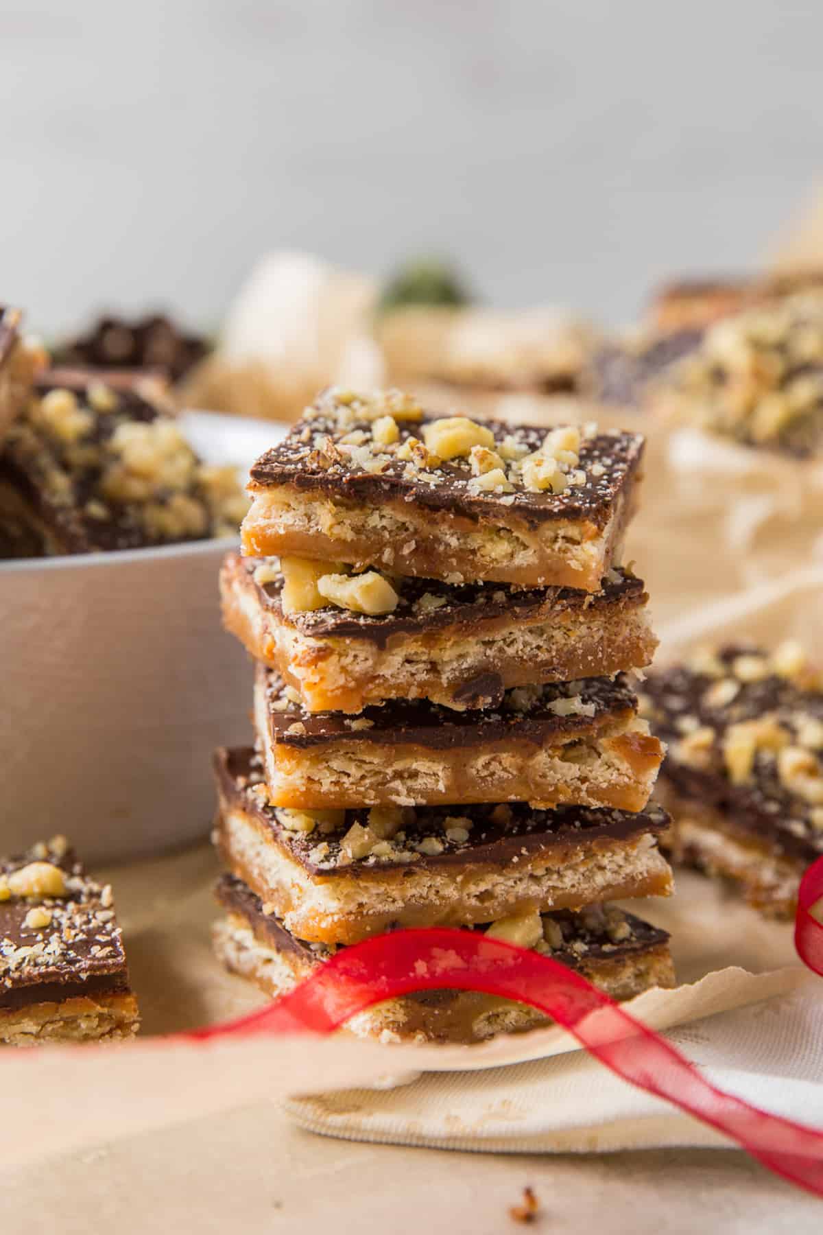 Pieces of toffee candy stacked on parchment paper.