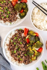 Bowls filled with rice, ground beef, and vegetables shot from over the top.
