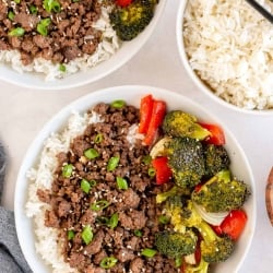 Bowls filled with rice, ground beef, and vegetables shot from over the top.