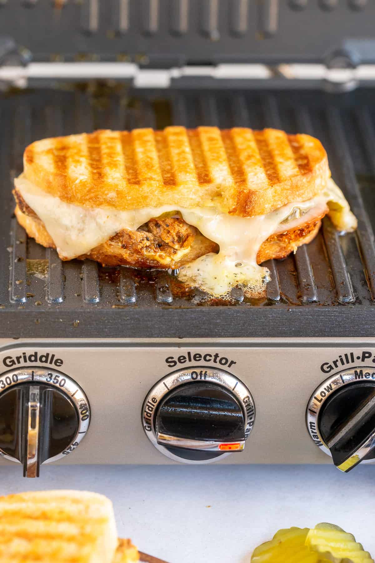 A cuban sandwich being cooked on a panini press.