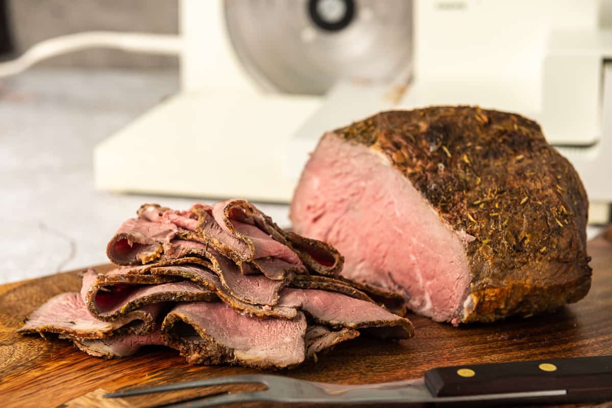 Sliced roast beef on a cutting board.