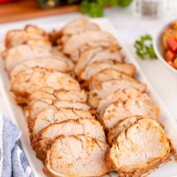 Sliced pork tenderloin on a serving platter.