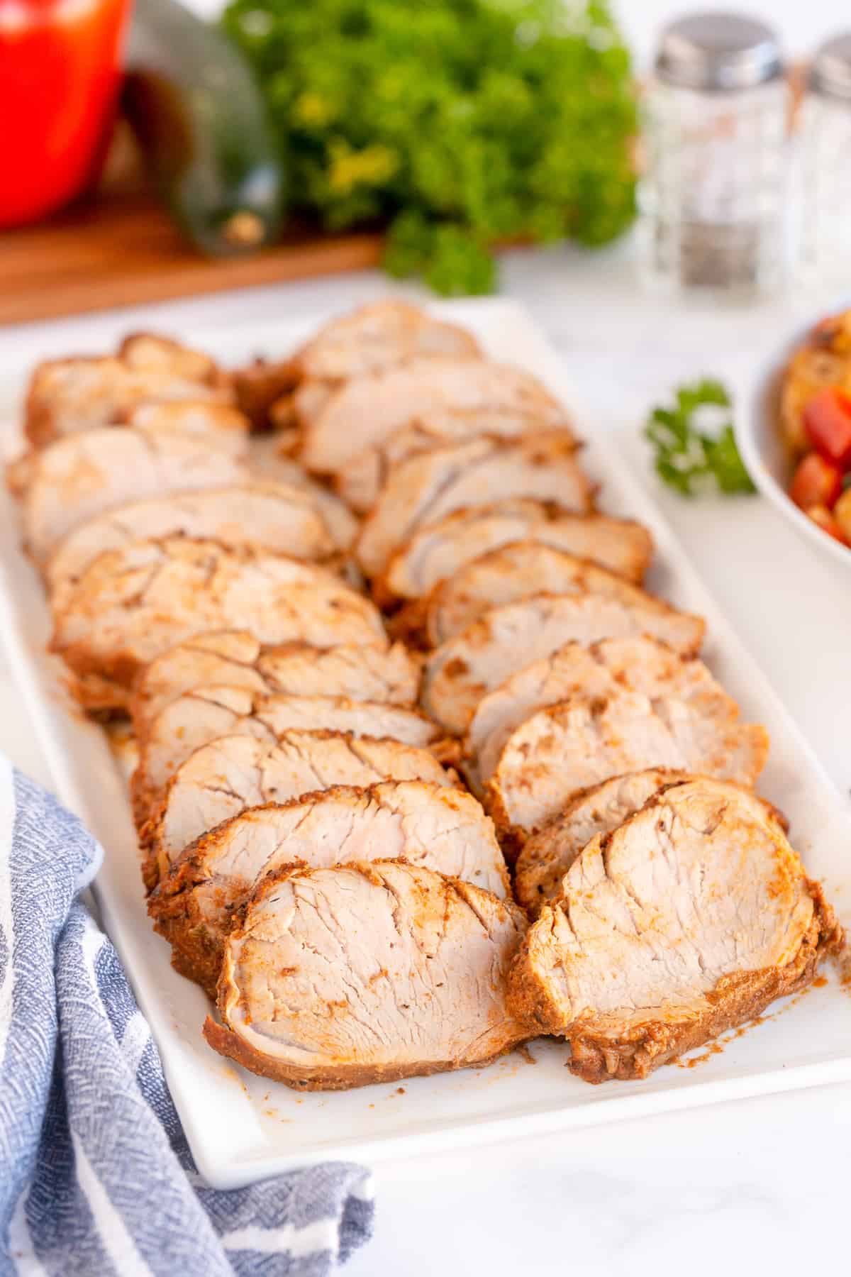 Sliced pork tenderloin on a serving platter.