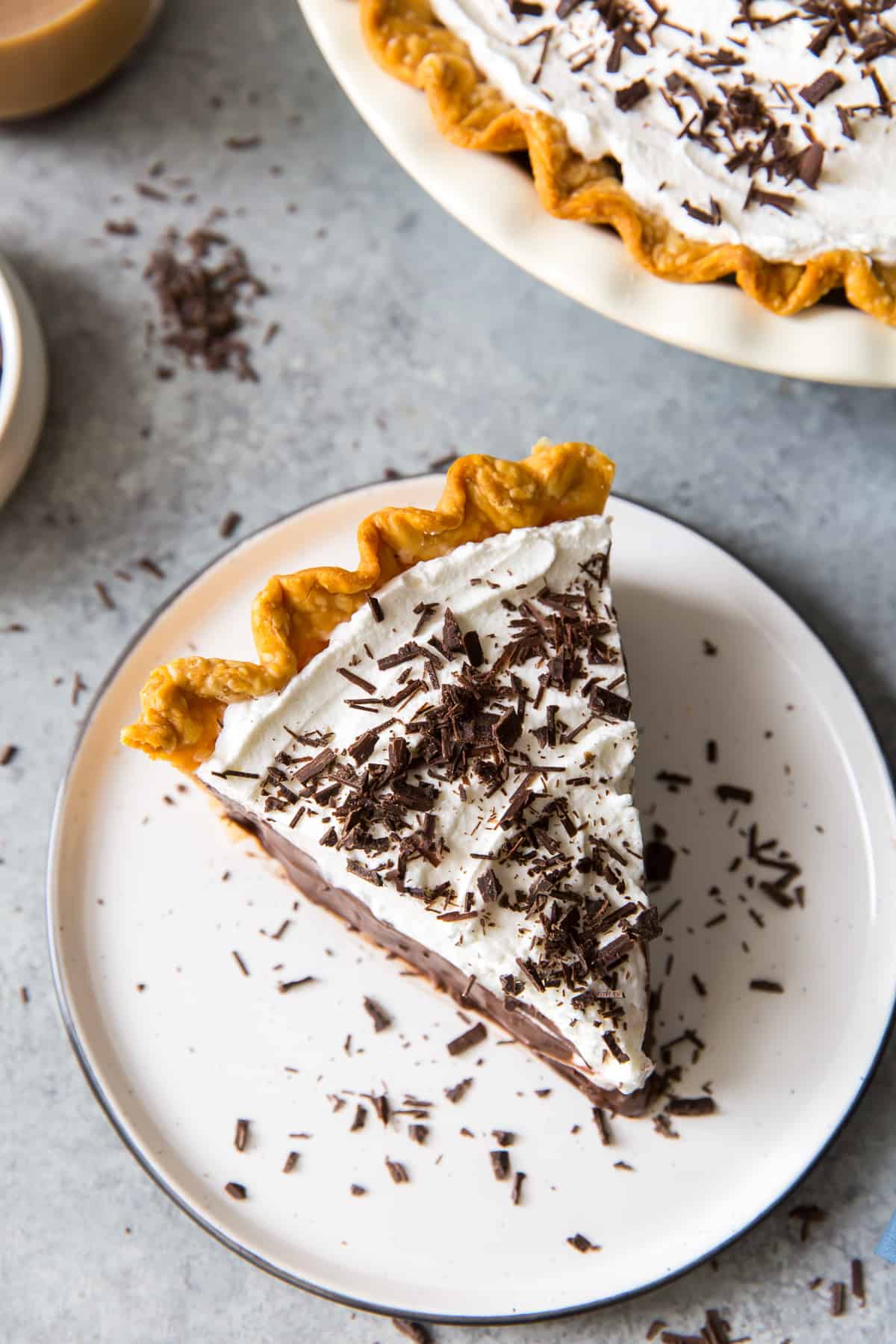 A slice of chocolate pie topped with whipped cream and chocolate shavings shot from over the top.