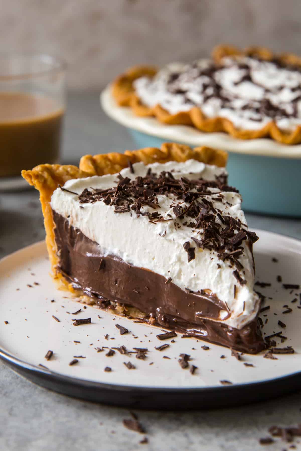 A slice of Chocolate Cream Pie on a white plate.