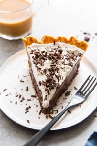 A slice of chocolate pie on a white plate with a fork.