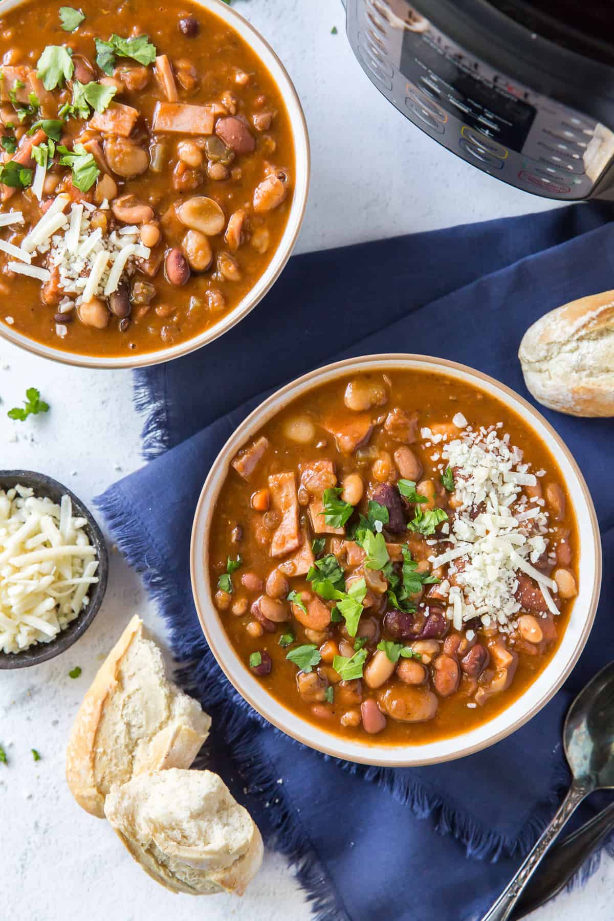 Two bowls of bean soup in front of an Instant Pot.