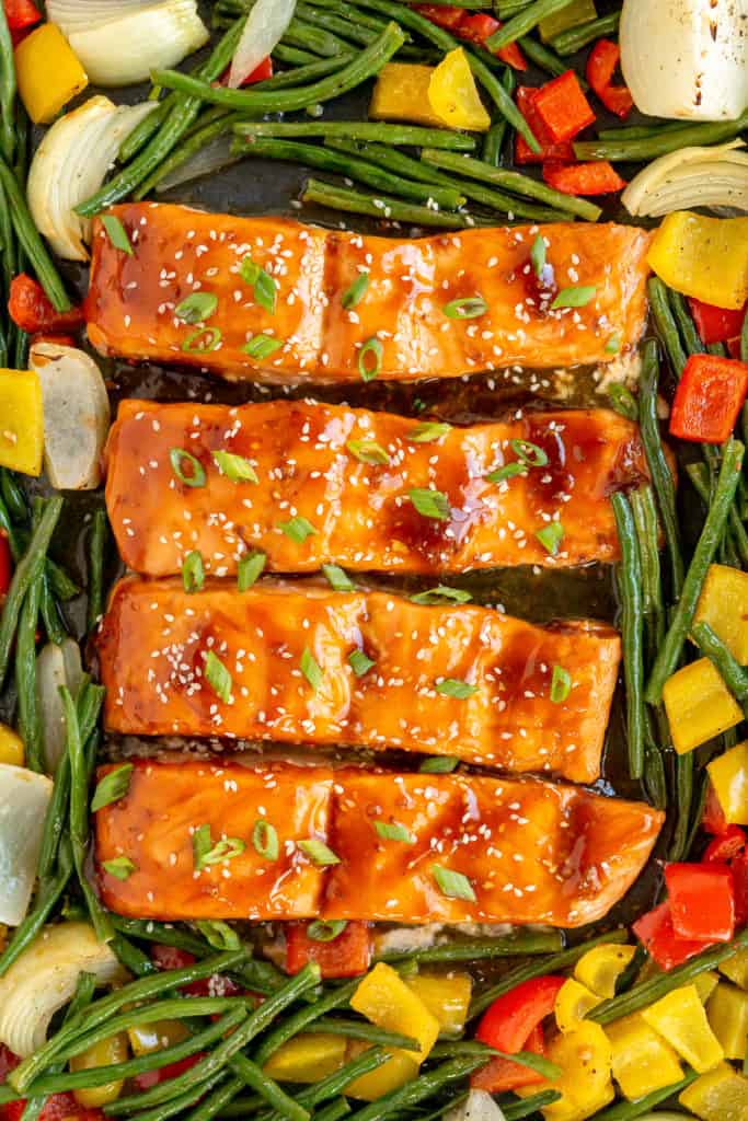 Cooked salmon on a sheet plan with vegetables.