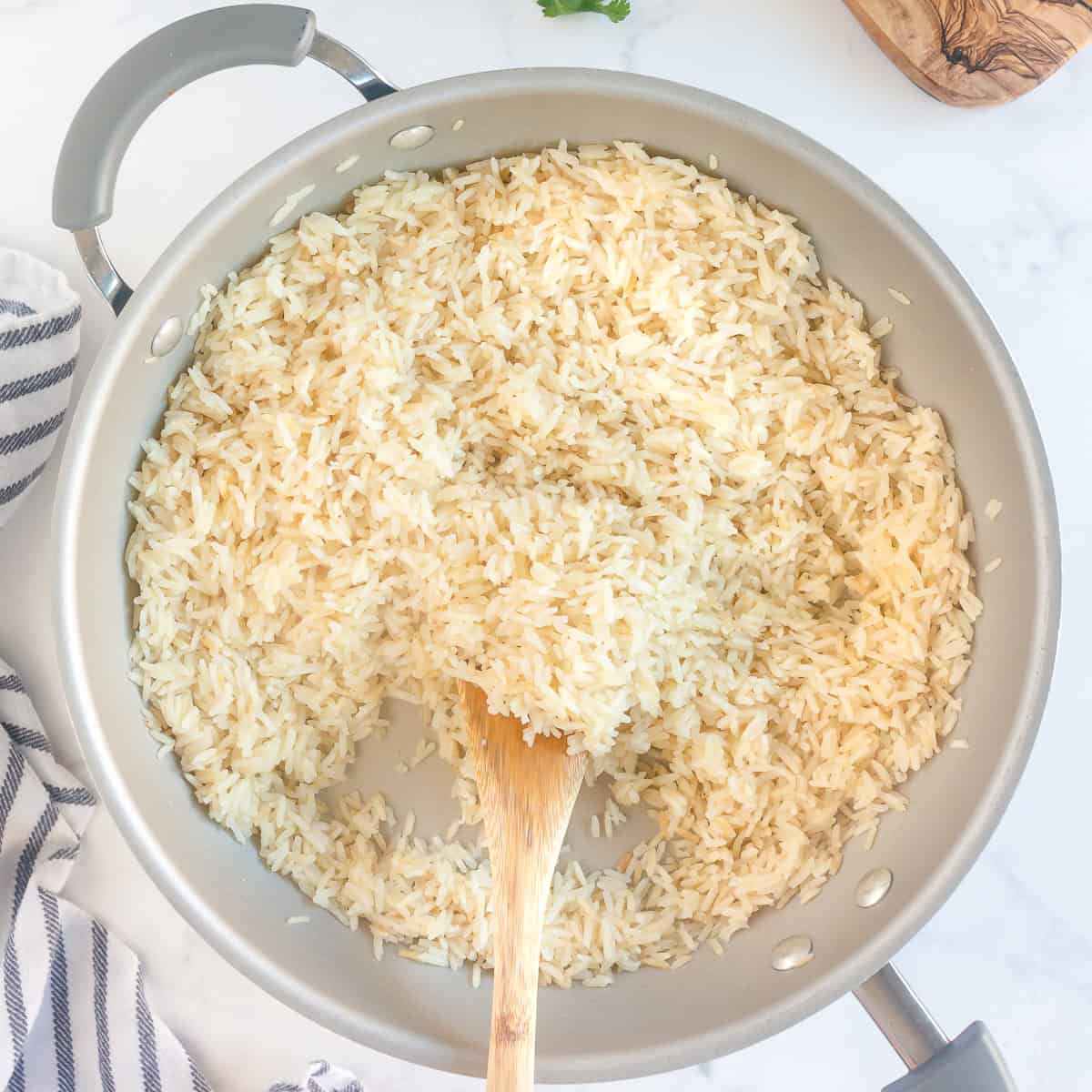 Cooked rice fluffed with a spoon before adding the lime juice and cilantro.