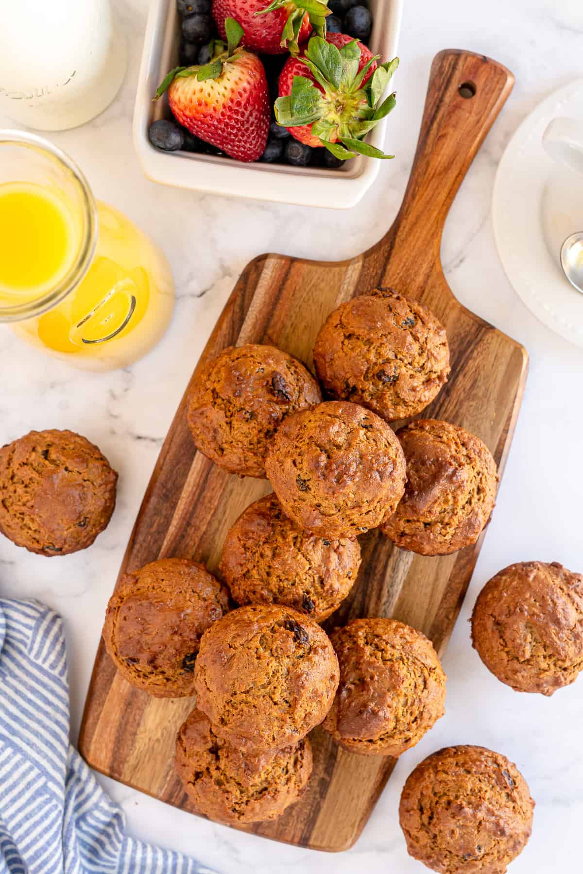 Bran muffins piled on to a cutting board and shot from over the top.