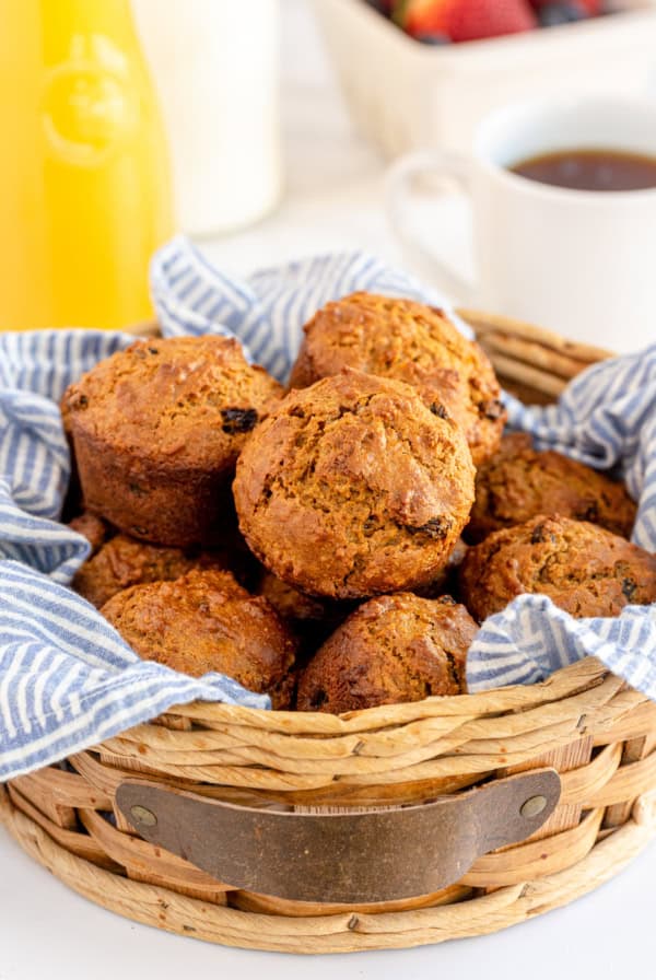 A basket lined with a blue cloth and filled with bran muffins.