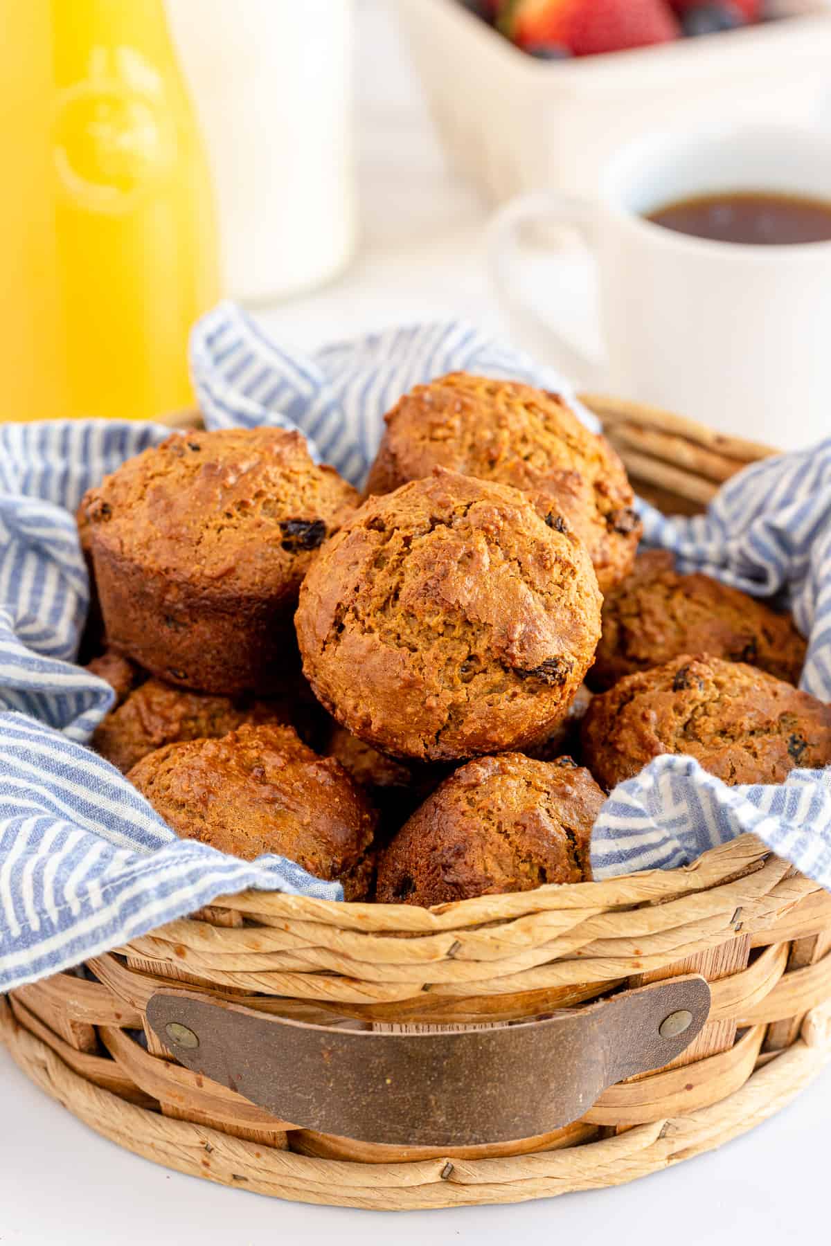 A basket lined with a blue cloth and filled with bran muffins.