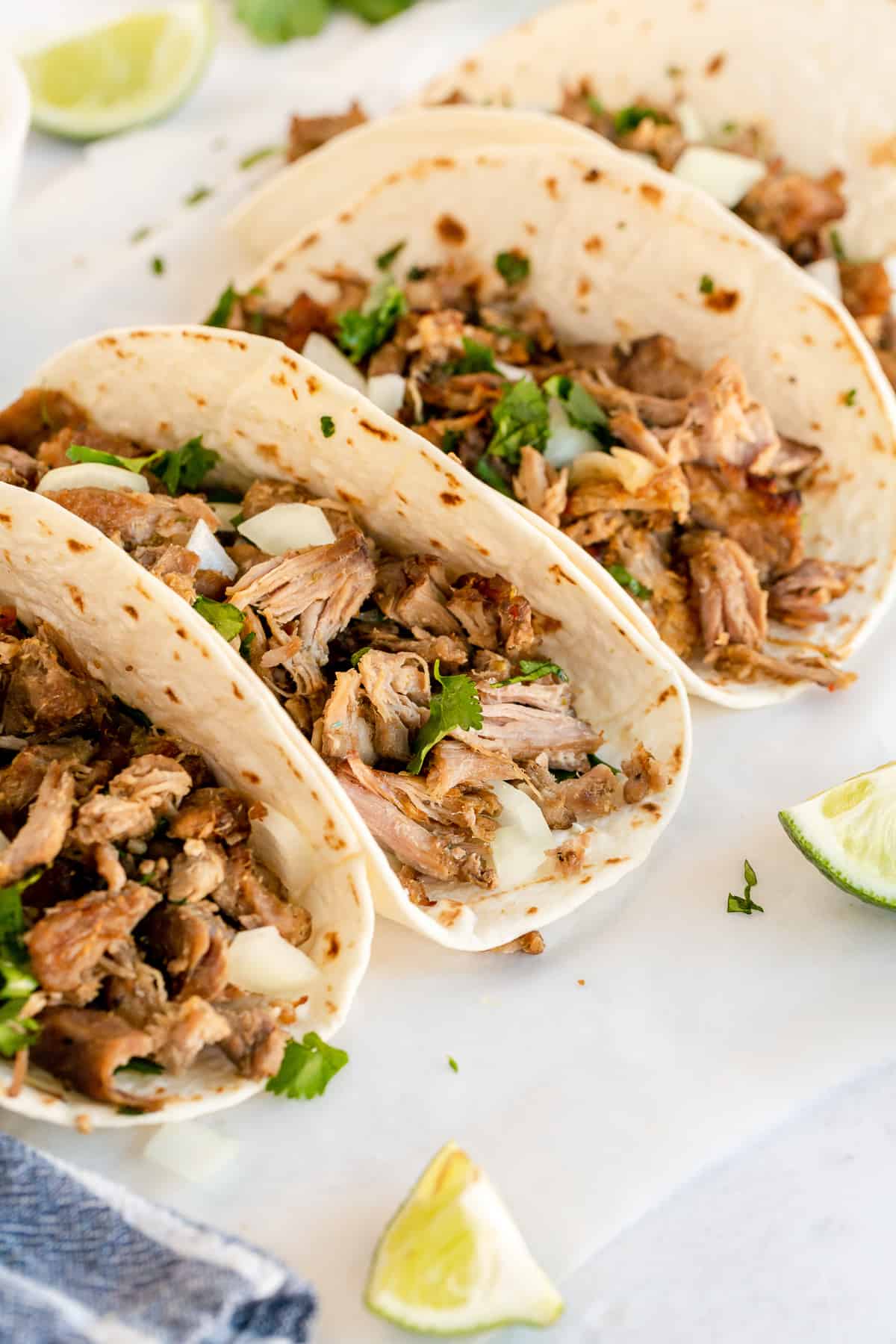 Three carnitas tacos on a platter.