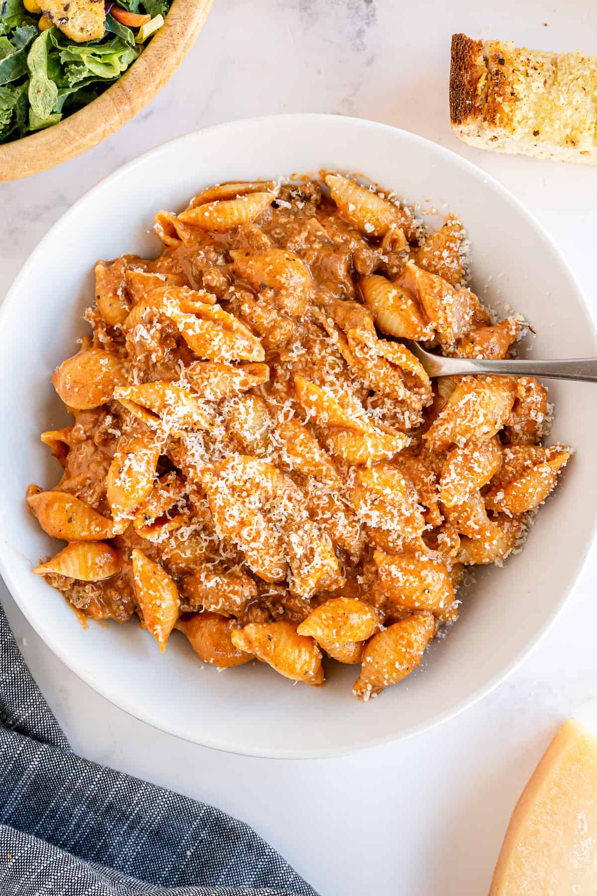 A bowl of pasta shells with beef and a creamy sauce shot from over the top.