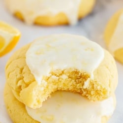 A glazed cookie stacked on top of another with a bite missing.