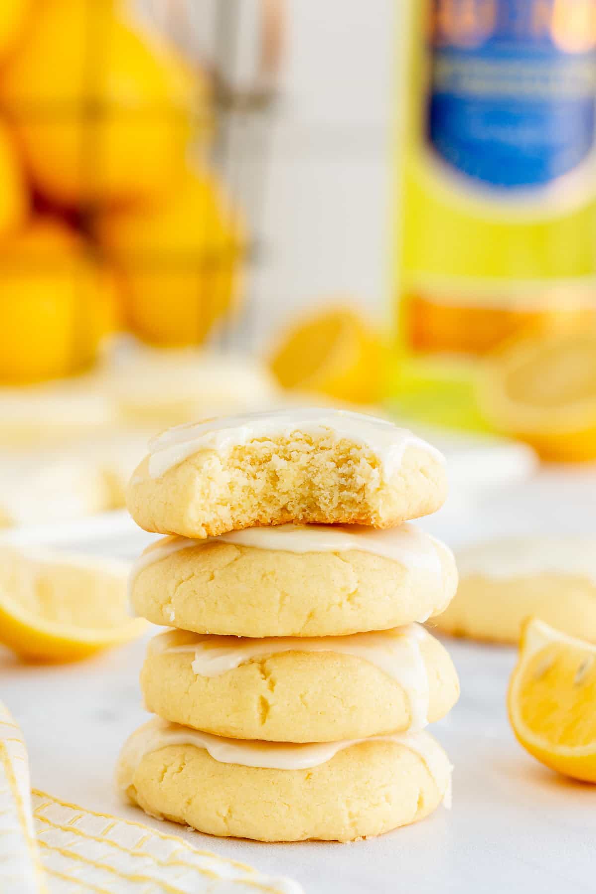 A stack of lemon cookies with a bite missing from the one on top.