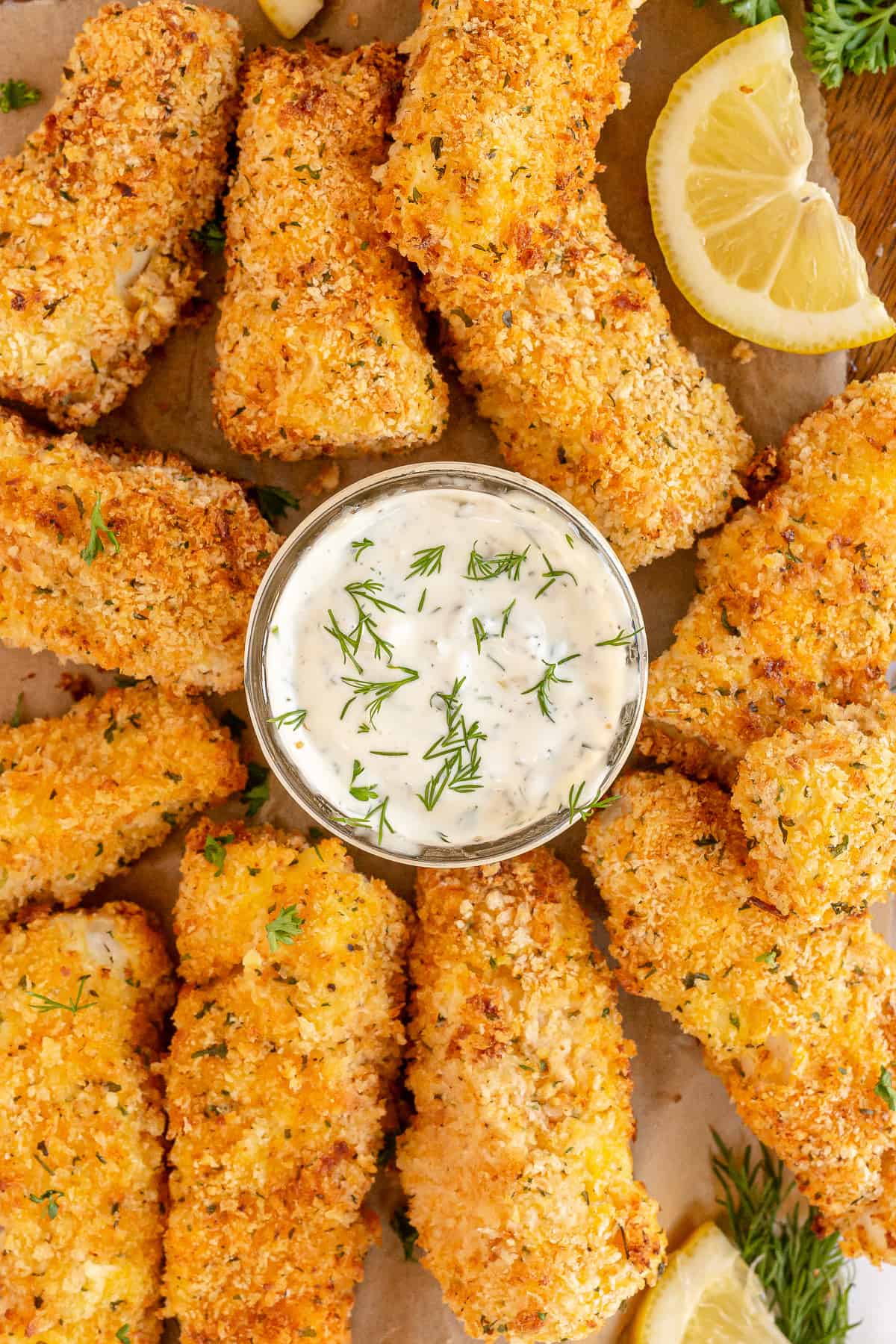 A jar of tartar sauce in the middle of fish sticks.