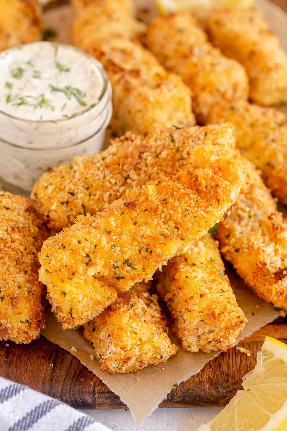 A stack of Air Fryer Fish Sticks and a jar of tartar sauce.