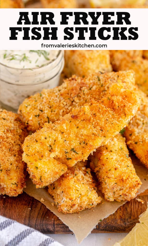 A pile of fish sticks on a parchment paper lined board with text.