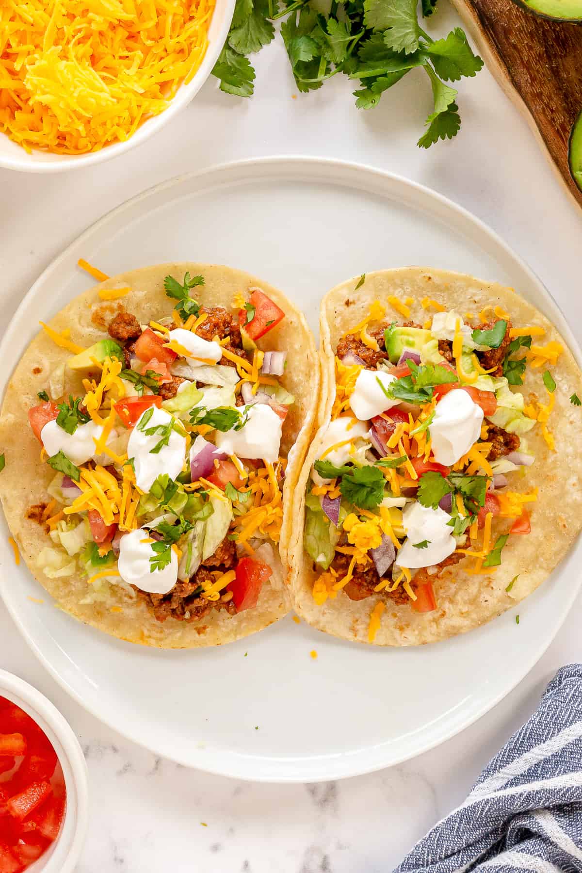 Two tortillas with taco filling on a plate.