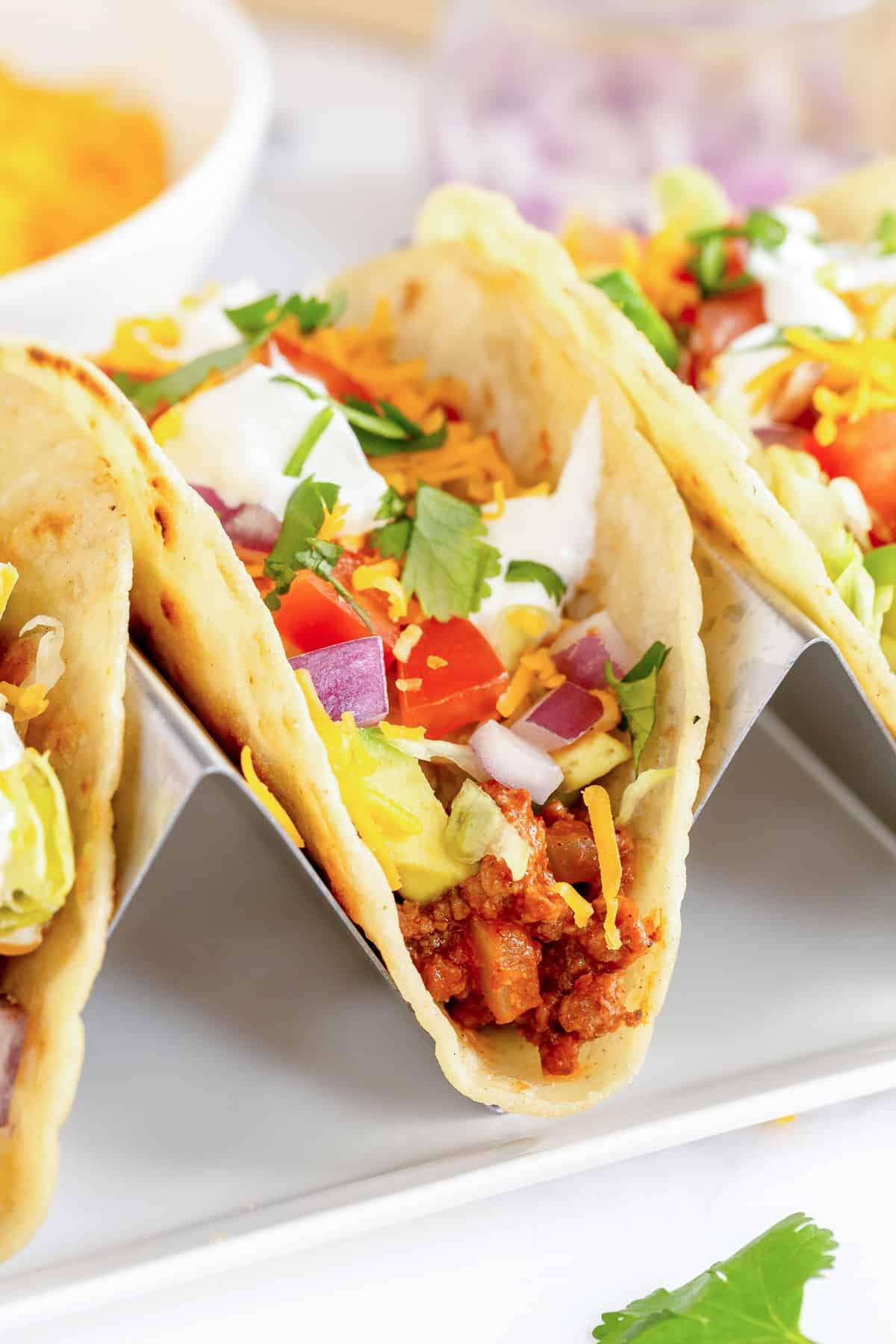 Tacos with ground beef and toppings in a taco stand.