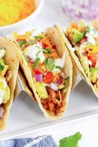 Three ground beef tacos in a taco stand.