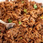 A fork digs into a bowl of Instant Pot Beef Barbacoa.