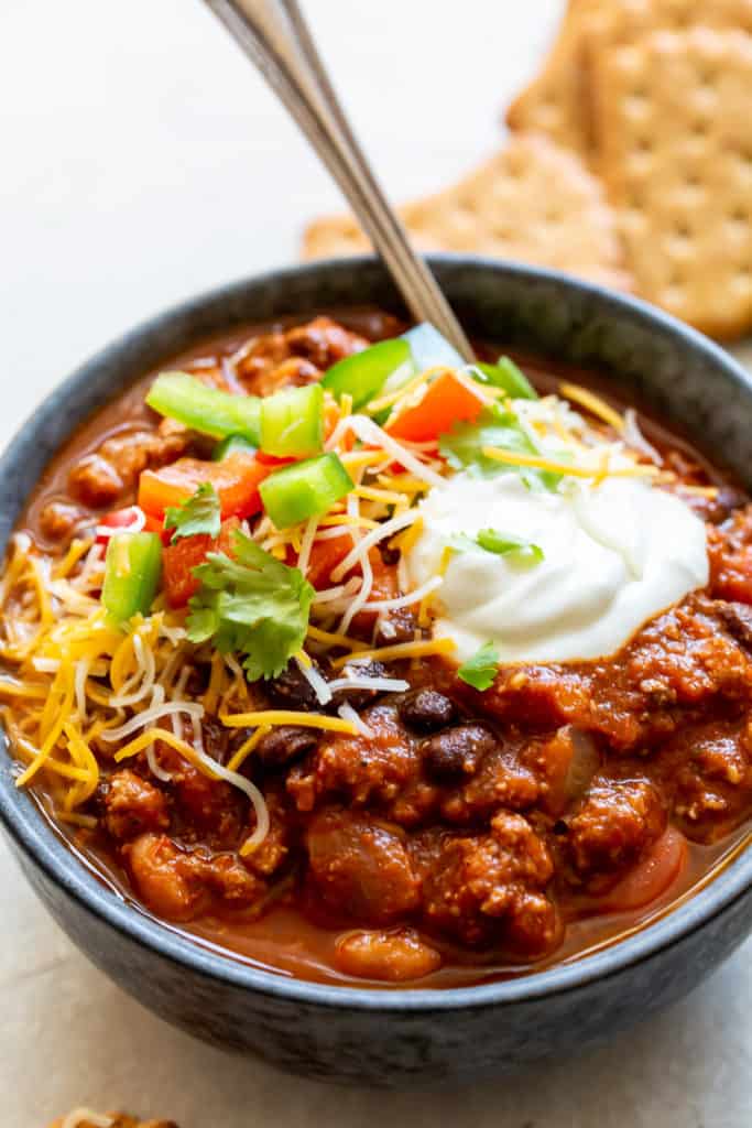 A spoon in a bowl of chili.