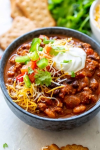 A bowl of chili loaded with toppings.