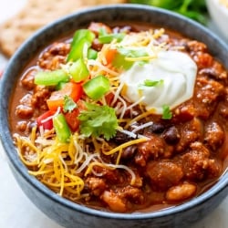 A bowl of chili loaded with toppings.