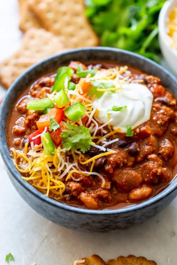 A bowl of chili loaded with toppings.
